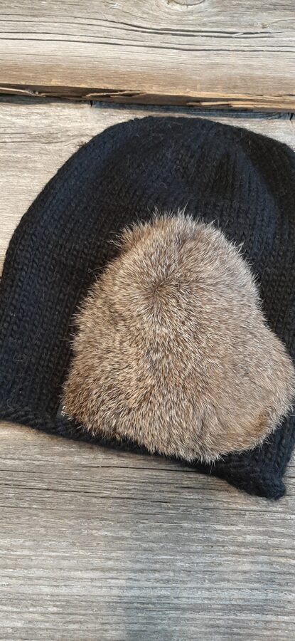 Melna cepure ar dabīgo kažokādu. Vienā eksemplārā.  Mīksta, silta, stilīga adīta rokām no kvalitatīvas alpakas un merīno dzijas. 