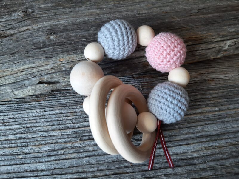 Lalu dabīga koka graužamriņķis ar aptamborētām koka bumbiņām. Rotaļlieta - grabulis bērniem. Zobgrauzis.