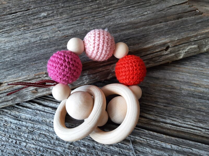 Lalu dabīga koka graužamriņķis ar aptamborētām koka bumbiņām. Rotaļlieta - grabulis bērniem. Zobgrauzis.