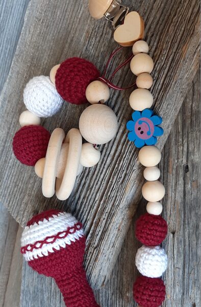 Lalu grabuļu komplekts mazuļiem ''Sarkanbalti sarkanais".  Graužamriņķis, knupīšu turētājs un grabulis kātiņā ar maigas skaņas zvārgulīti. 