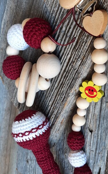 Lalu grabuļu komplekts mazuļiem ''Sarkanbalti sarkanais".  Graužamriņķis, knupīšu turētājs un grabulis kātiņā ar maigas skaņas zvārgulīti. 