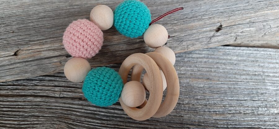 Lalu dabīga koka graužamriņķis ar aptamborētām koka bumbiņām. Rotaļlieta - grabulis bērniem. Zobgrauzis.