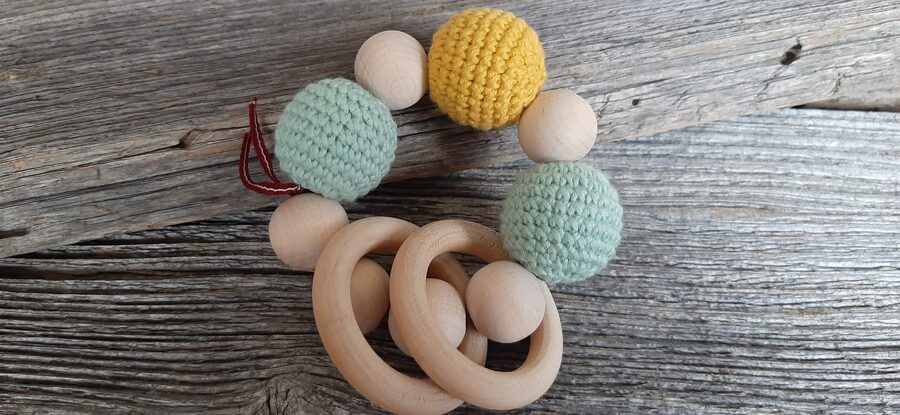 Lalu dabīga koka graužamriņķis ar aptamborētām koka bumbiņām. Rotaļlieta - grabulis bērniem. Zobgrauzis.