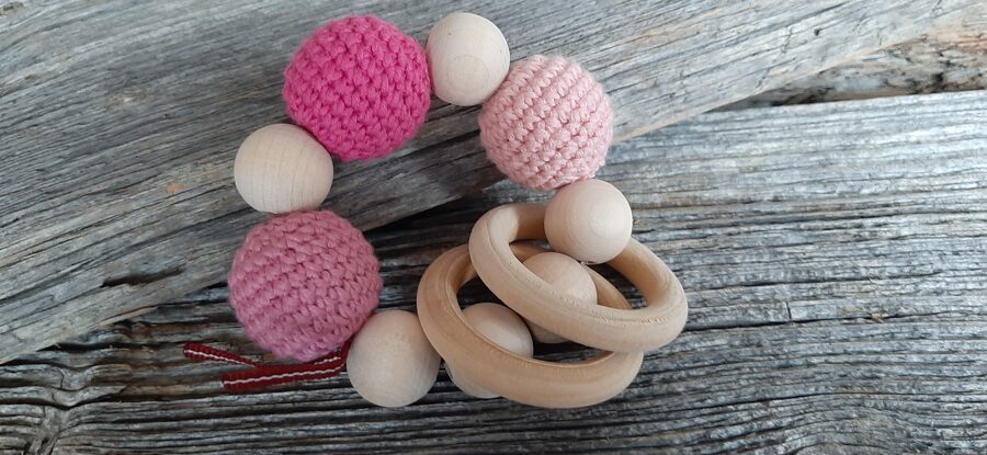 Lalu dabīga koka graužamriņķis ar aptamborētām koka bumbiņām. Rotaļlieta - grabulis bērniem. Zobgrauzis.