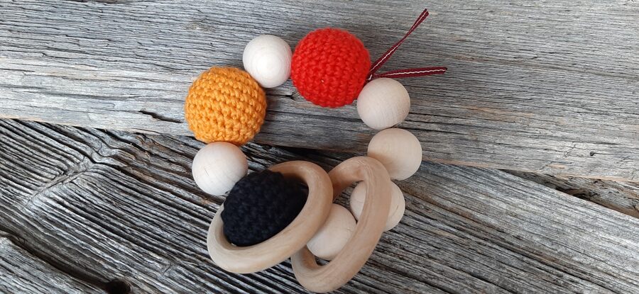 Lalu dabīga koka graužamriņķis ar aptamborētām koka bumbiņām. Rotaļlieta - grabulis bērniem. Zobgrauzis.