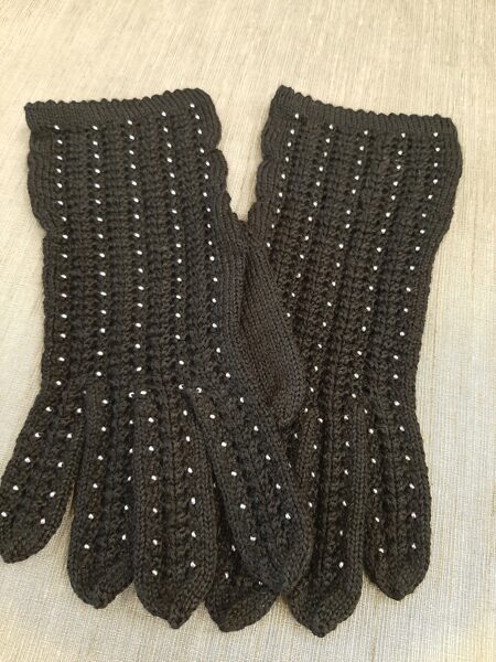 Skaisti un eleganti sieviešu pirkstaiņi ieadītām gaiša zelta krāsas pērlītēm. Vilnas cimdi.