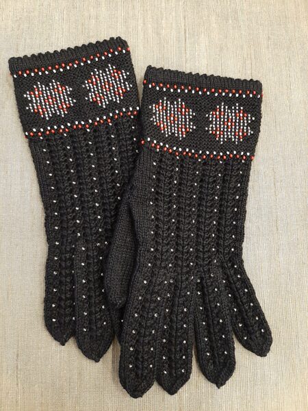 Skaisti melni un eleganti sieviešu pirkstaiņi ieadītām pērlītēm. Vilnas cimdi.
