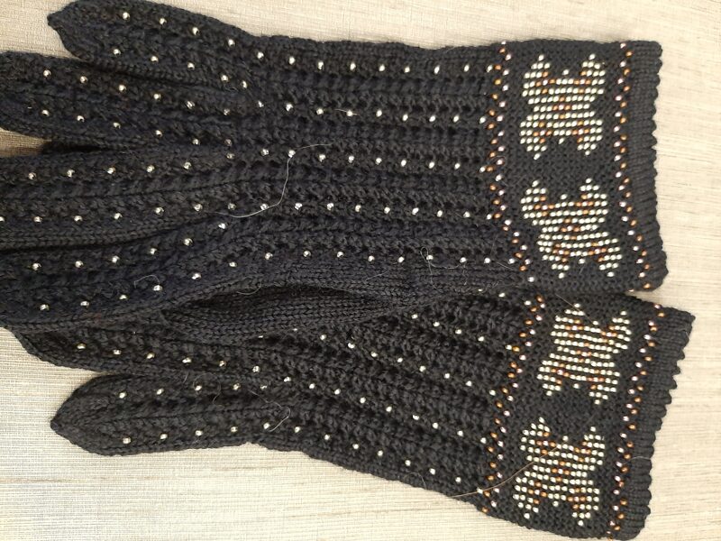 Skaisti melni un eleganti sieviešu pirkstaiņi ieadītām pērlītēm. Vilnas cimdi.