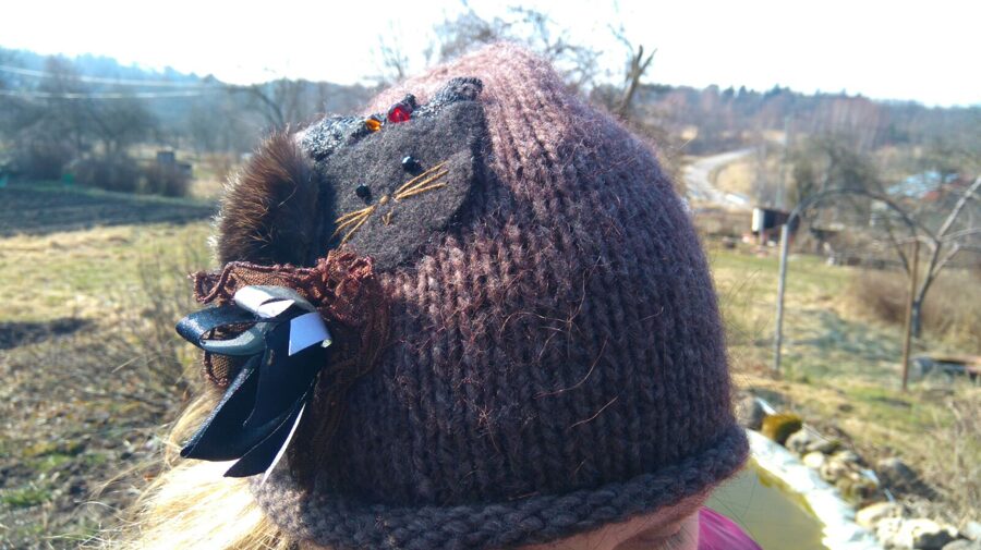 Cepurīte dekorēta ar mežģīnēm un kaķīti jaunai dāmai.